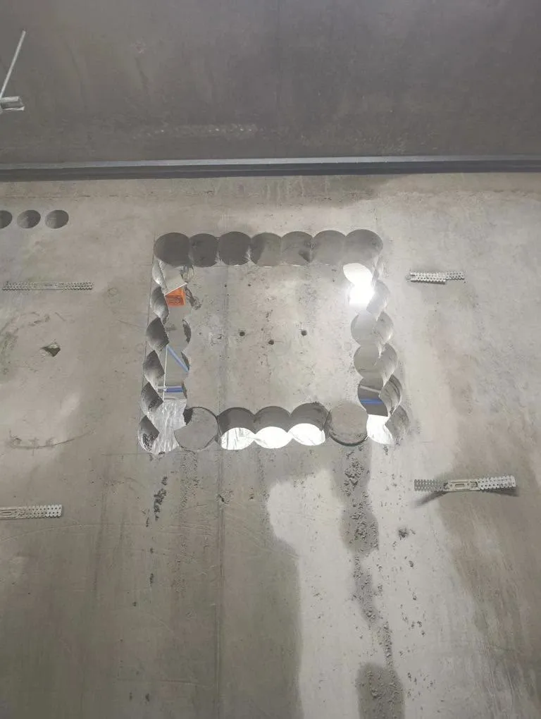 Rectangular opening formed by overlapping stitch-drilled cores through a concrete wall
