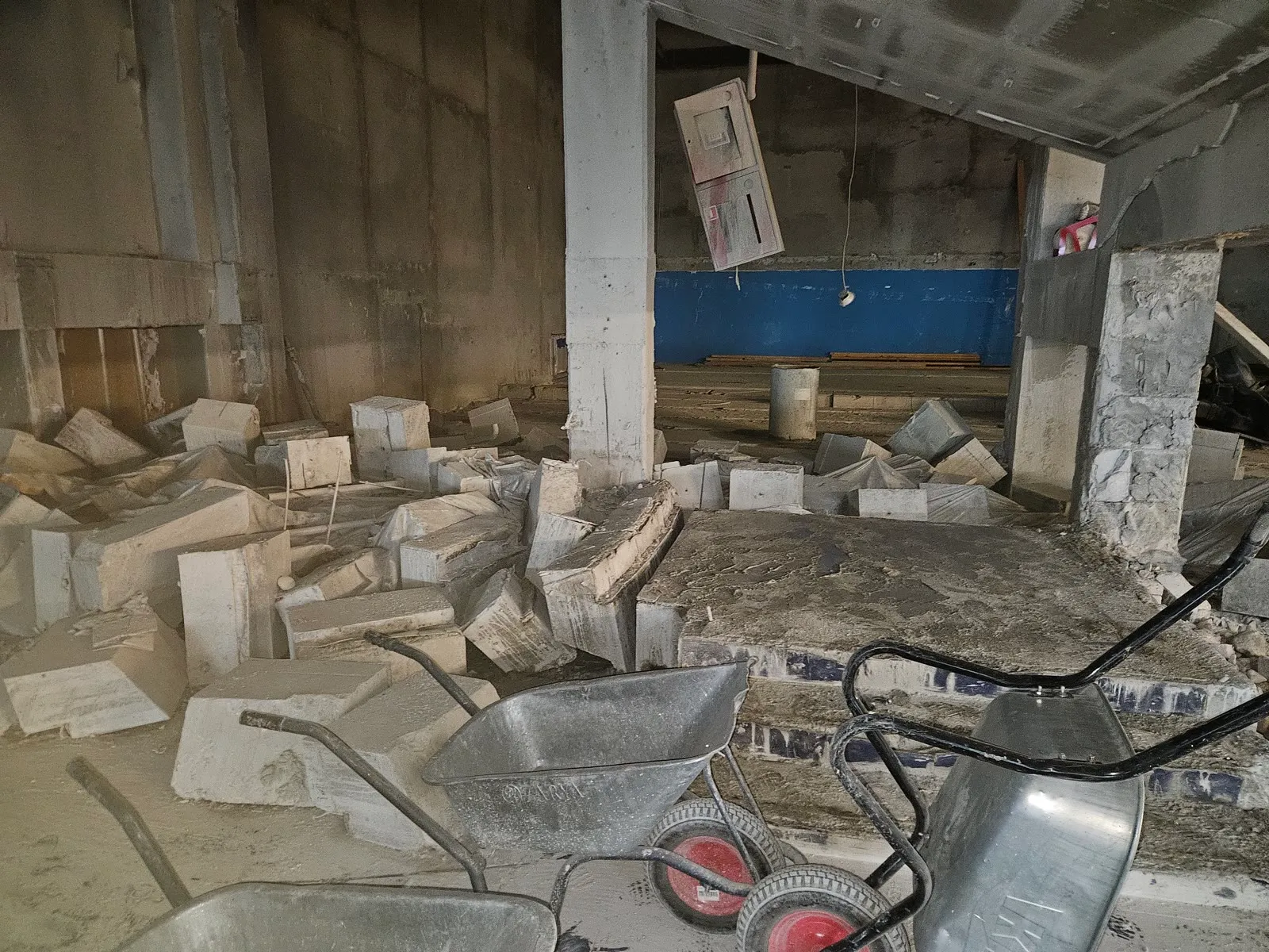Wall saw mounted high on a concrete bunker wall with the operator below